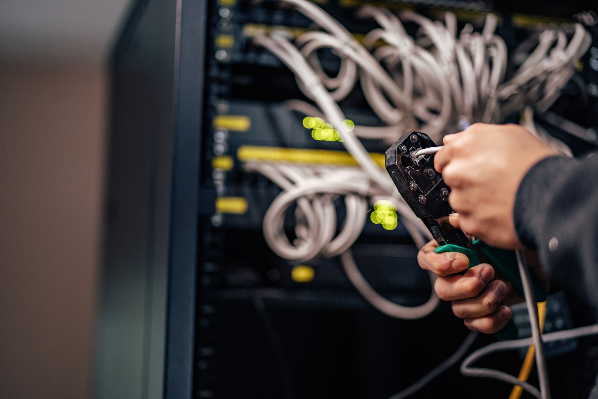Hands of a man using crimping tool on ethernet jack. Computer network laying procedure. Installing a new connector on ethernet cable.