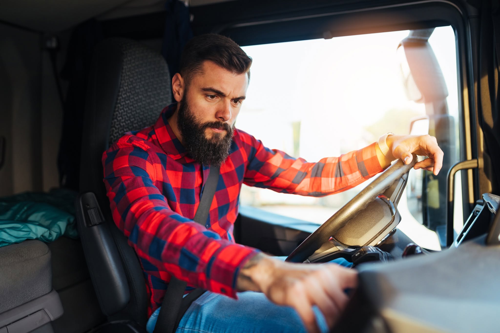 Young handsome bearded man driving his truck.